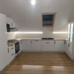 Kuchnia na wymiar pod skosem z czarnymi uchwytami i płytkami metro – Dariusz Kamiński