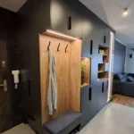 Szafa z siedziskiem, drewnianym panelem i haczykami – funkcjonalne rozwiązanie do przedpokoju