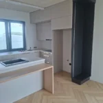 Kuchnia na wymiar z jasnymi frontami, wyspą i drewnianym barkiem, wykończenie w toku